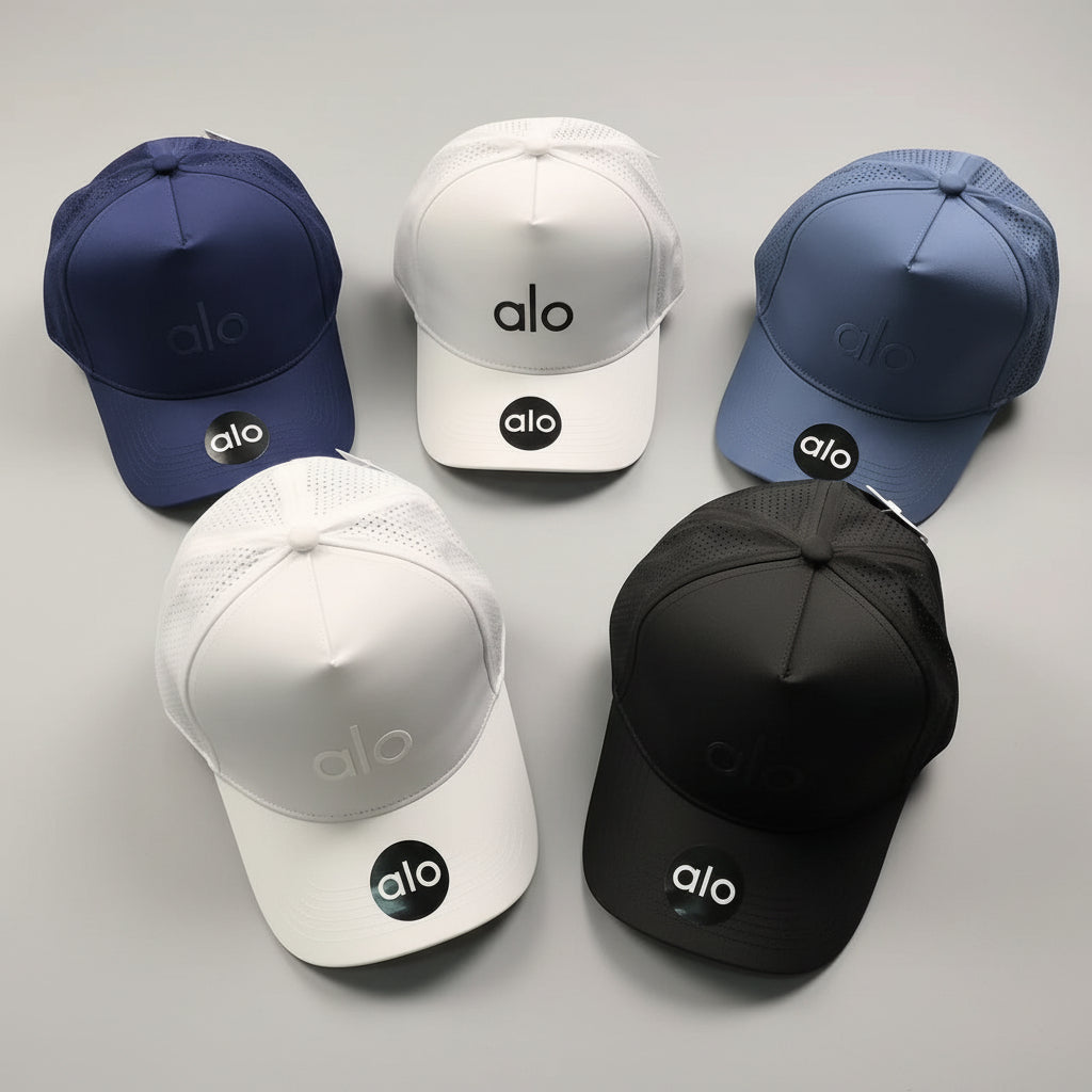 Five baseball caps in different colors with 'alo' branding on a gray surface.